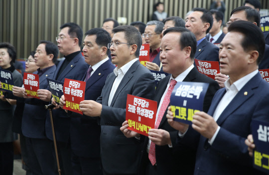 황교안 한국당 대표와 심재철 원내대표 등이 19일 국회에서 열린 의원총회에서 &quot;선거법 협상은 민주당과 군소 야당의 밥그릇 싸움&quot;이라고 구호를 외치고 있다.  연합뉴스